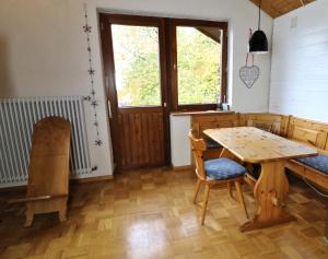 una sala da pranzo con tavolo e sedie in legno di Ferienwohnung Tannenblick - 3 Schlafzimmer, Feldberg-Falkau a Hinterfalkau
