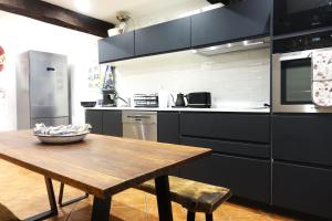 a kitchen with a wooden table and a wooden table sidx sidx sidx at Maison Vermeille Emplacement exceptionnel in Argelès-sur-Mer