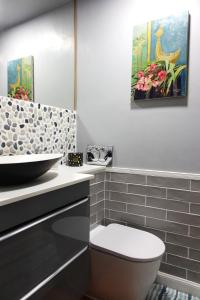 La salle de bains est pourvue de toilettes blanches et d'un lavabo. dans l'établissement Maison Vermeille Emplacement exceptionnel, à Argelès-sur-Mer