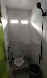 y baño pequeño con aseo y ducha. en SPOT ON 93326 Pondok Anie Syariah, en Pekanbaru
