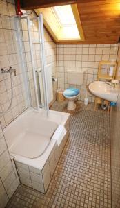 ein Badezimmer mit einer Badewanne, einem WC und einem Waschbecken in der Unterkunft Ferienwohnung Tannenblick - 3 Schlafzimmer, Feldberg-Falkau in Hinterfalkau