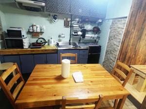 cocina con mesa de madera con sillas y fregadero en Wasaike House, en Osaka