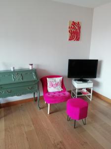 a living room with a green desk and a pink chair at '' Sète à Vous'' in Sète
