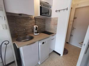 una pequeña cocina con fregadero y microondas en 028 Cap City B25, en Cap d'Agde