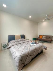 a bedroom with a large bed and a couch at Let's Go Homestay in Kuching