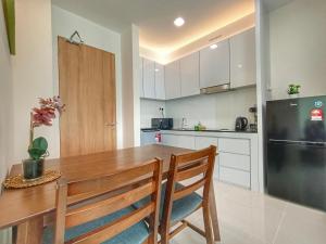 eine Küche mit einem Holztisch und einem Kühlschrank in der Unterkunft Let's Go Homestay in Kuching