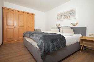 1 dormitorio con 1 cama grande con manta negra en Appartements Alpengarten, en Mallnitz