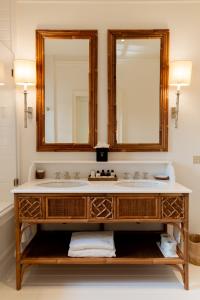a bathroom with a sink and two mirrors at California Park Hotel in Forte dei Marmi