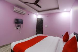 1 dormitorio con 1 cama y TV en la pared en OYO 63814 The New View Hotel, en Greater Noida