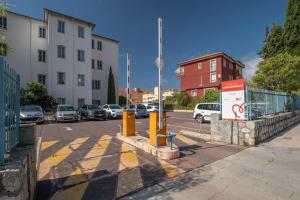 a street with cars parked in a parking lot at Hôtel Miléade L'Orangeraie - Menton in Menton