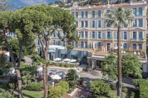 an aerial view of a hotel with palm trees at Hôtel Miléade L'Orangeraie - Menton in Menton