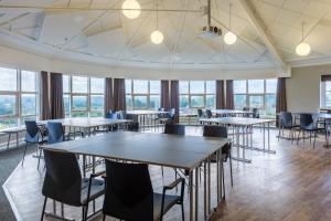 ソーレにあるThon Partner Hotel Sorøのテーブルと椅子、窓が備わる広い客室です。