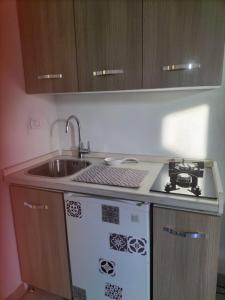 uma cozinha com um lavatório e um fogão em Casa Alma monolocale per 2 persone em Porto Ercole