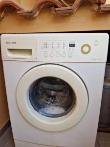 uma máquina de lavar roupa branca sentada num quarto em Casa Alma monolocale per 2 persone em Porto Ercole