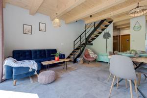 Sękowa的住宿－Leśna Chata domek z balią，客厅设有蓝色的沙发和楼梯。