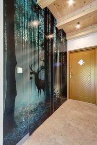 a wall mural of a deer in the forest at Leśna Chata domek z balią in Sękowa