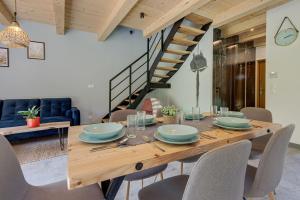 a dining room with a wooden table and chairs at Leśna Chata domek z balią in Sękowa