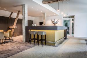 a lobby with a bar with chairs and a table at Hotel B - Boskapelhoeve in Buggenhout