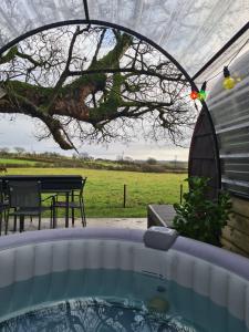 a hot tub in a tent with a picnic table at Loughmourne Glamping Pod 