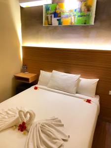 Un dormitorio con una cama blanca con flores. en Asiana Lovina Hotel en Lovina