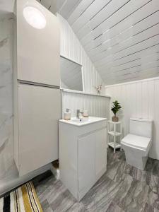 a white bathroom with a sink and a toilet at (S16) Bright Leeds City House in Roundhay