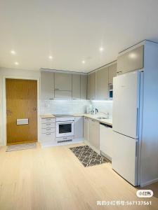 a kitchen with white cabinets and a refrigerator at Cityhome Kaarto in Rovaniemi