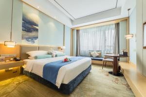 Century Runhua Hotel في جينان: غرفة نوم بها سرير كبير ومكتب