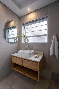 łazienka z białą umywalką i oknem w obiekcie The Blonde Bungalow Ballito w mieście Ballito