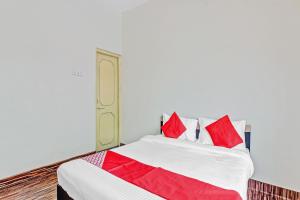 ein Schlafzimmer mit einem Bett mit roten Kissen in der Unterkunft OYO Shree Balaji Lodging in Chikalthān