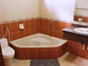 a bathroom with a tub and a toilet and a sink at Nareto House in Arusha