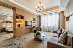 a living room with a couch and a bedroom at Century Runhua Hotel in Jinan