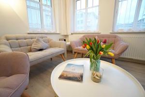 ein Wohnzimmer mit einem Tisch mit Blumen darauf in der Unterkunft Haus Vilma in Ahlbeck