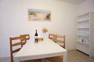 einen weißen Tisch mit einer Flasche Wein und einem Weinglas in der Unterkunft Haus Vilma in Ahlbeck + 20 Fotos