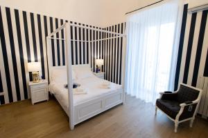 a bedroom with a white canopy bed and a chair at Le residenze del capitano in Bari