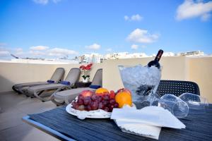 a table with a plate of fruit and a bottle of wine at Blubay Apartments by ST Hotels in Il-Gżira