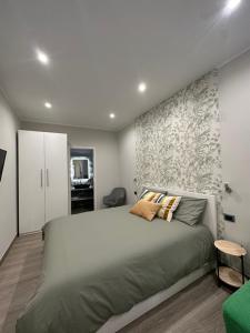 Un dormitorio con una cama grande y una pared en B&b Sanem Luxury rooms, en Gioia Tauro