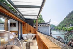 a balcony with a tub and a view of a river at Moon River View Hotel in Fenghuang County