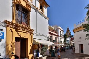科爾多瓦的住宿－Posada de la Judería II，一群人沿着街道走着,街道上有许多建筑