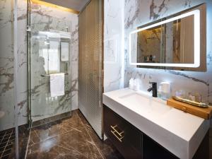 a bathroom with a sink and a shower at Moon River View Hotel in Fenghuang County