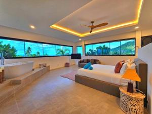 una camera con un grande letto e una vasca da bagno di Luxury Villa - Chaweng Noi Seaview - 6 bedroom - Gym et cinema room a Nathon Bay