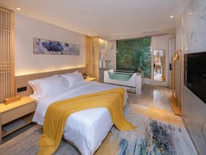 a bedroom with a large bed and a tub at Moon River View Hotel in Fenghuang County