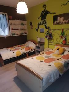 1 dormitorio con 2 camas y un futbolista en la pared en Christophe, en Crest