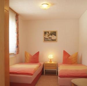 - 2 lits dans une chambre avec une lampe sur une table dans l'établissement Landhaus am Rennweg, à Neuhaus am Rennweg