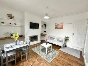 a living room with a table and a fireplace at (S17) Convenient 2BR Leeds - Sleeps 4 in Leeds