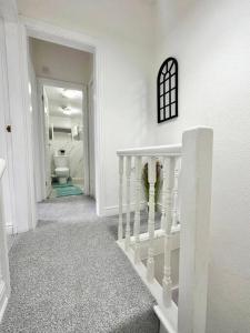 a white hallway with a staircase and a toilet at (S17) Convenient 2BR Leeds - Sleeps 4 in Leeds