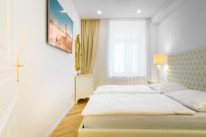ein weißes Schlafzimmer mit 2 Betten und einem Fenster in der Unterkunft Lé David City Apartments 1020 in Wien