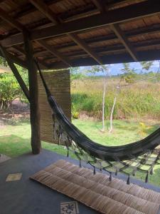 a hammock in a house with a view of a field at Rancho Blue in Marau