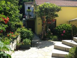 a garden with flowers and a yellow house at Apartments Matkovic in Kotor