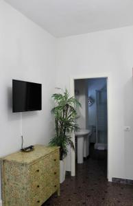una habitación con TV en una pared con dos plantas en Ciudad Jardín Marina, en Las Palmas de Gran Canaria