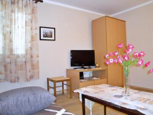 una sala de estar con un jarrón de flores sobre una mesa en Apartments Vila Nidisa, en Čižići